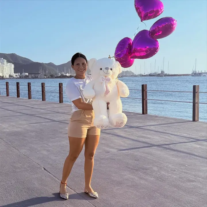 Cliente de Enkntadas con un peluche gigante y globos de corazón en el malecón de Santa Marta